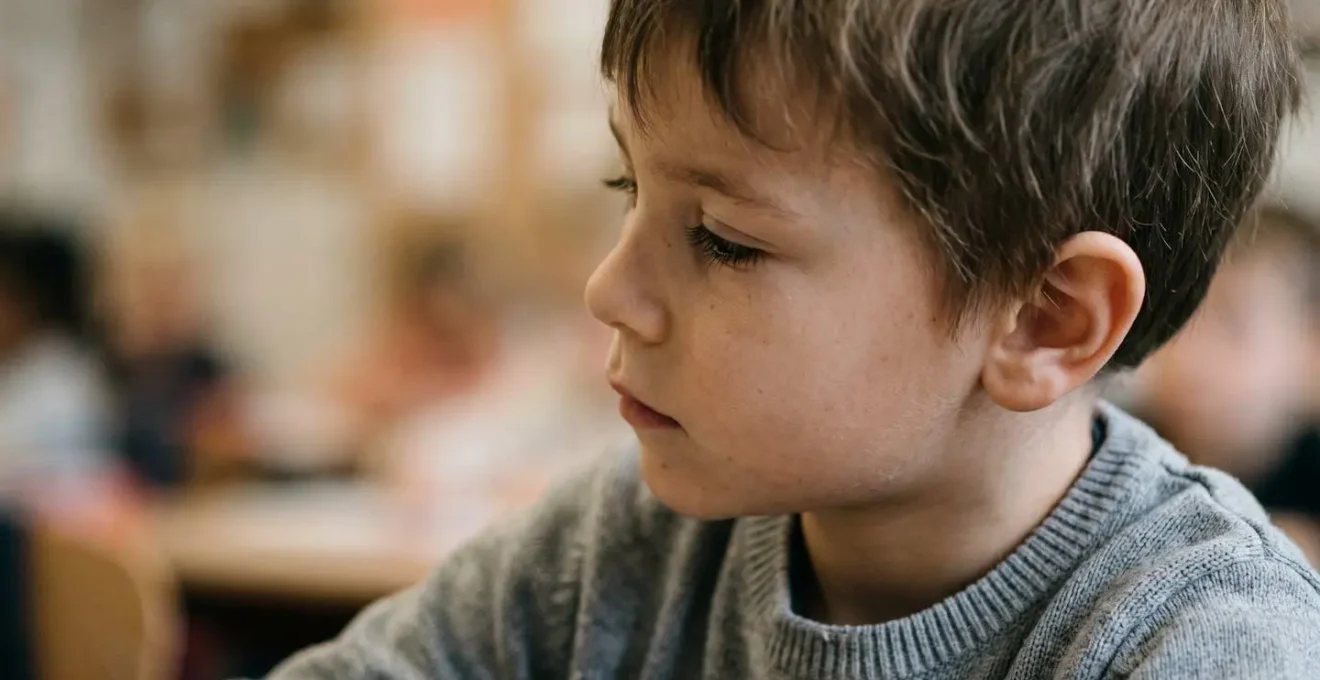 Close-up of a young child tilting head to compensate for hearing difficulty in learning environment