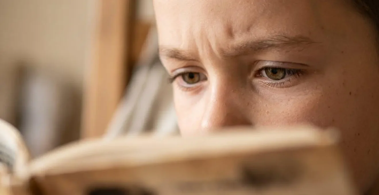 Close-up of child's focused expression while engaged in reading activity showing concentration and eye movement
