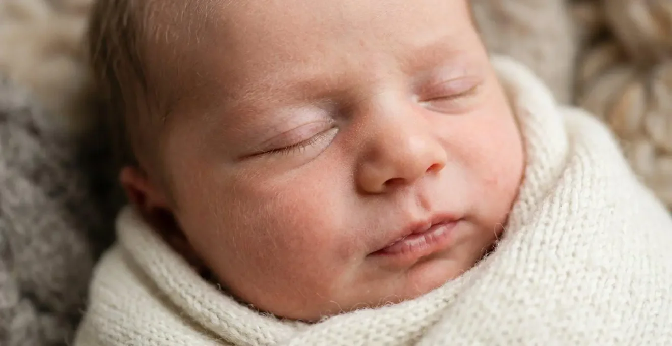Close-up of an infant's expressive face during social interaction, showing subtle emotional cues and connection attempts