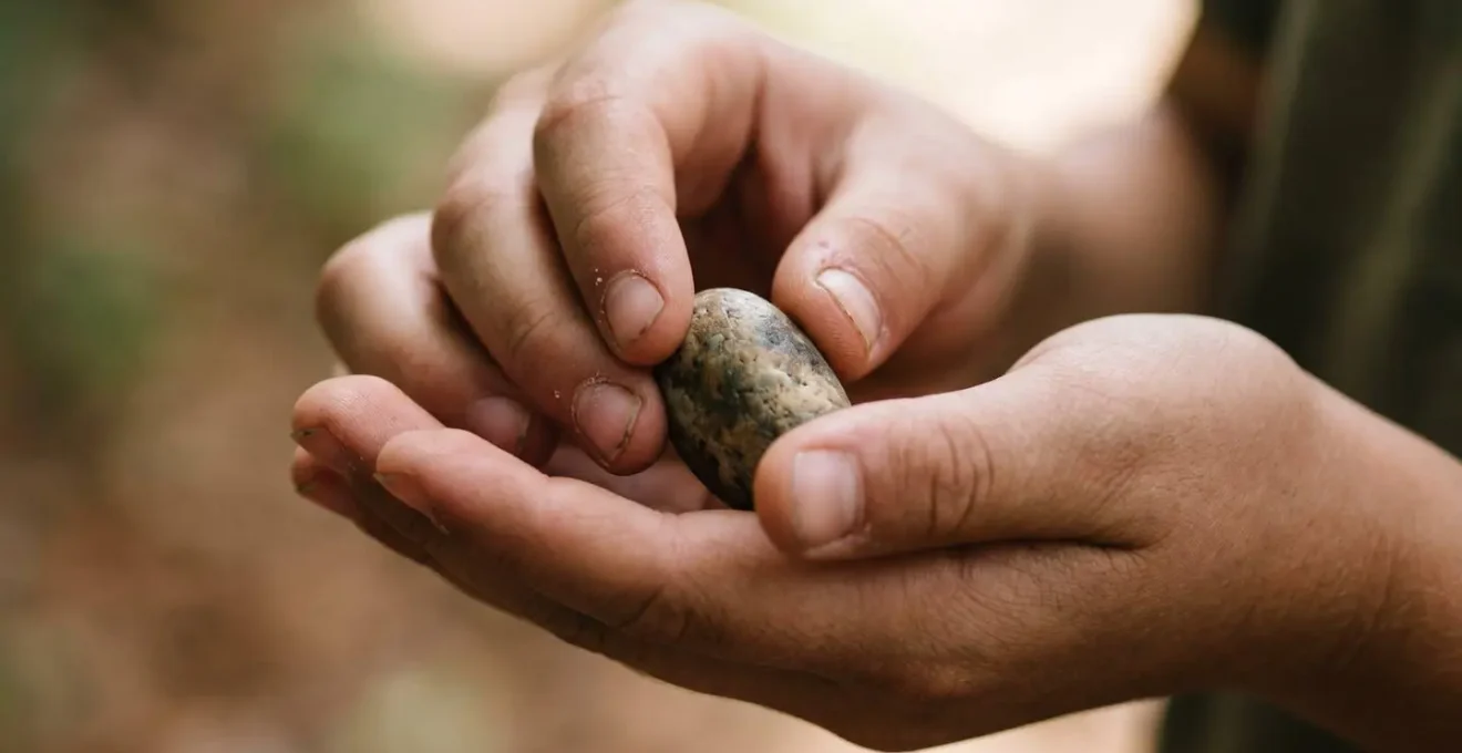 Close-up of a child's hands gently holding a small object with focused attention demonstrating patience